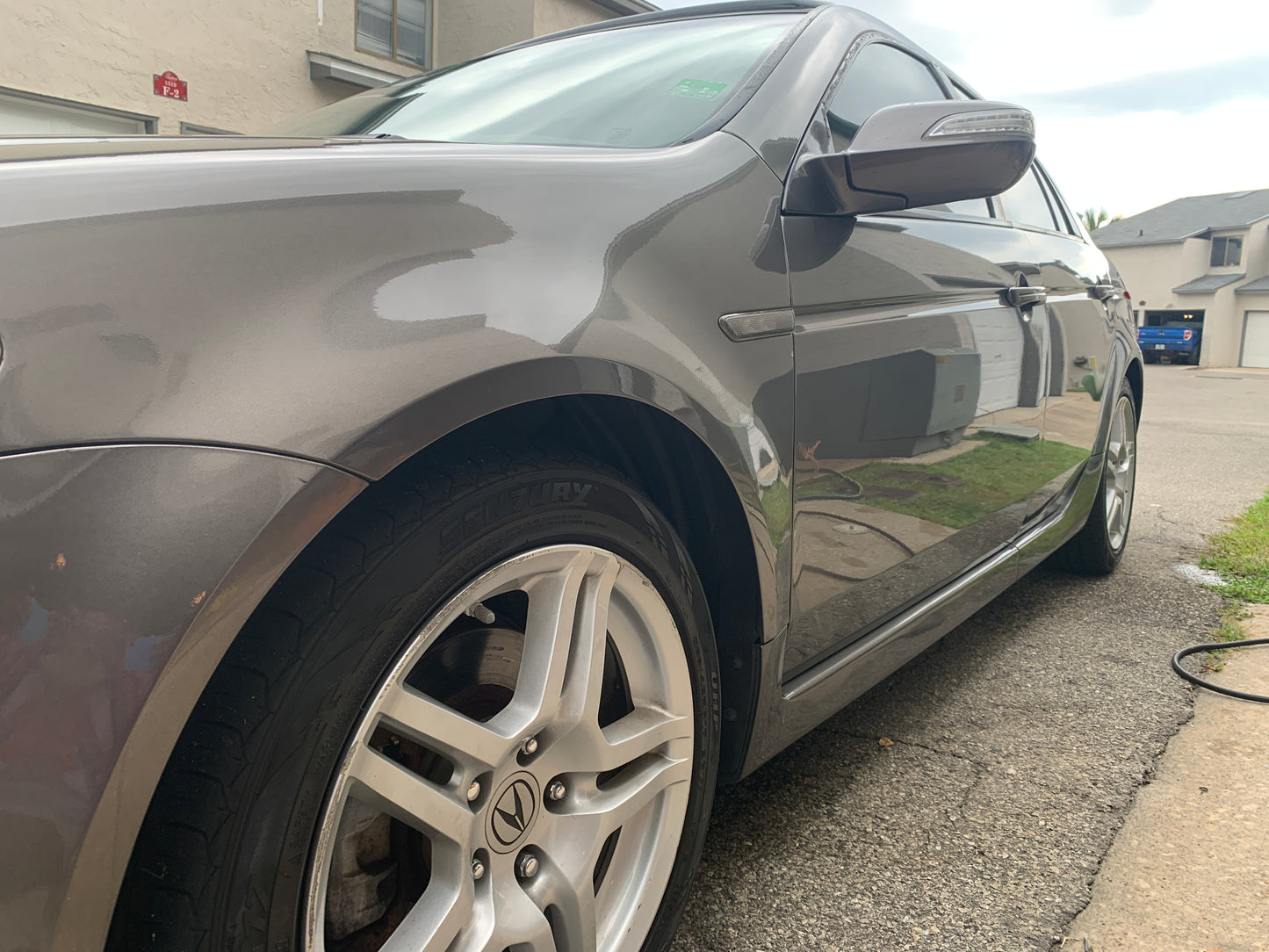 Acura TSX reflecting its surroundings after detailing, showcasing a smooth, glossy finish.