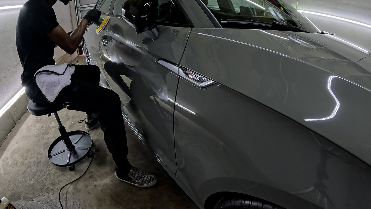Technician polishing the Audi S5’s paint, demonstrating the meticulous process of restoring a flawless surface through paint correction.