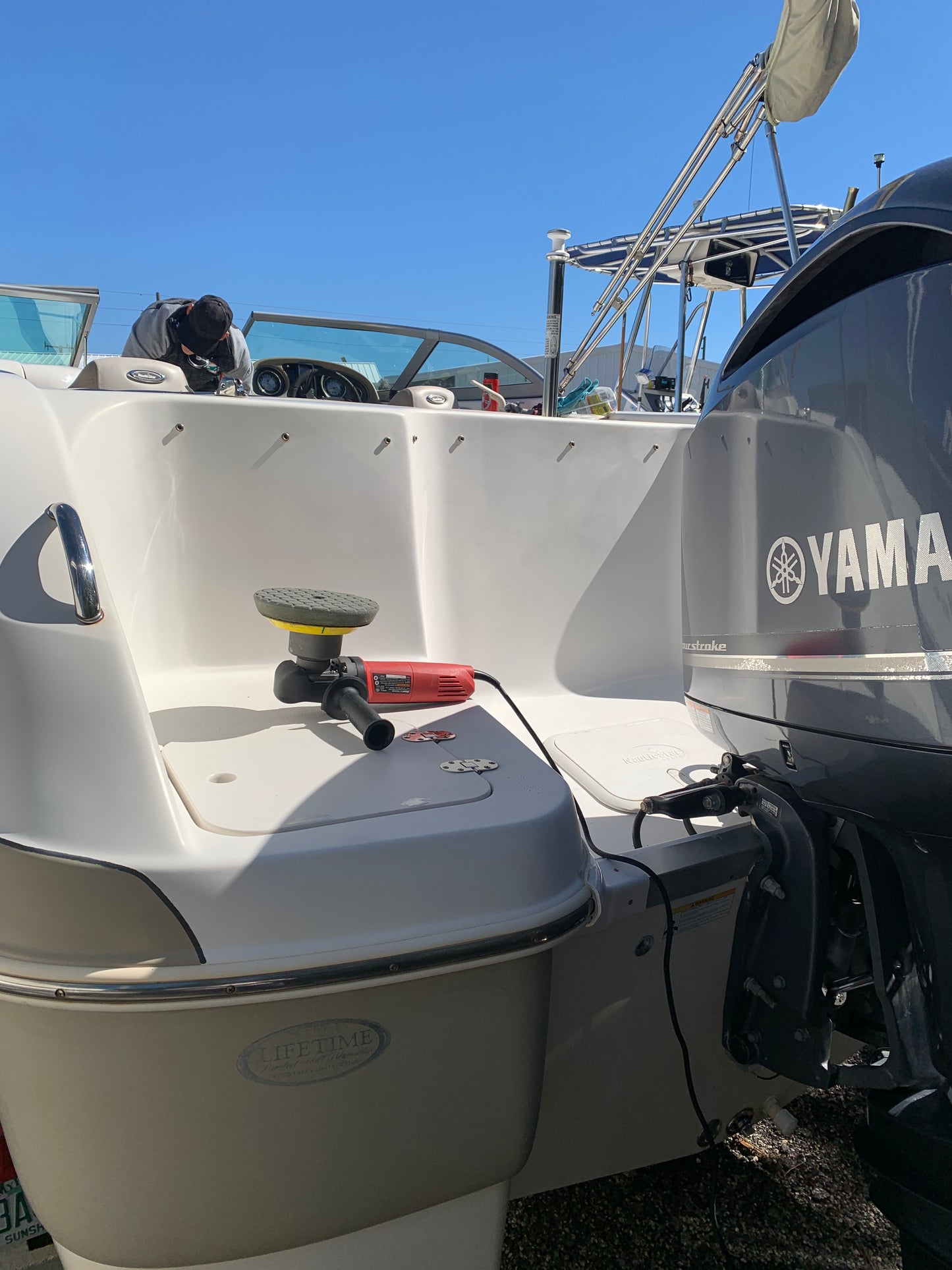 Waxing the rear of the boat and motor, applying a protective layer for a glossy, smooth finish.