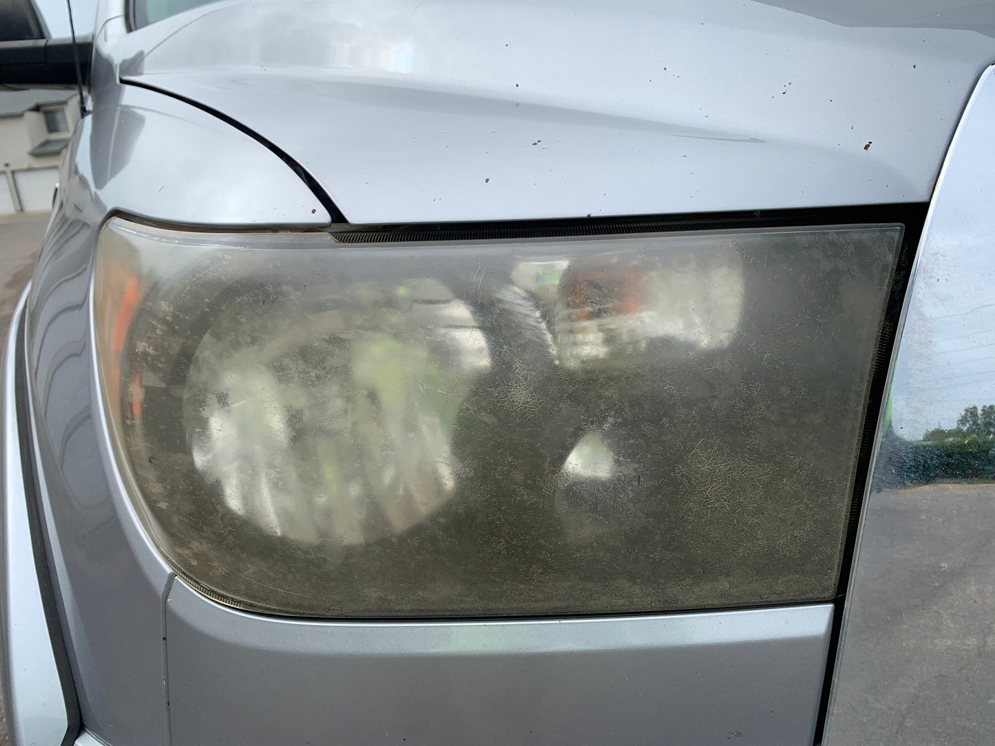 Headlight before restoration treatment showing yellowing and oxidation.