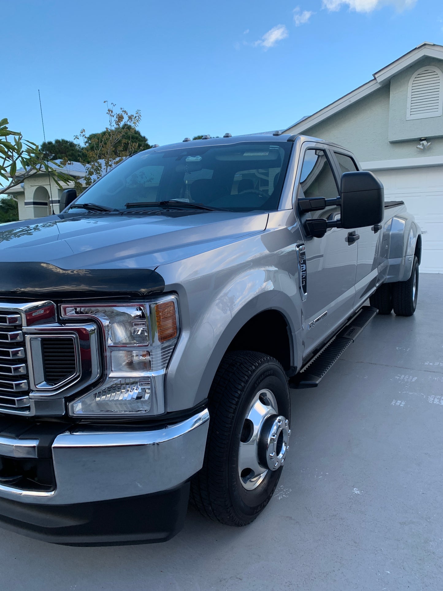 Mid-angle shot of the Ford F350, showcasing the front headlight to the rear tire, reflecting the surrounding environment after detailing.