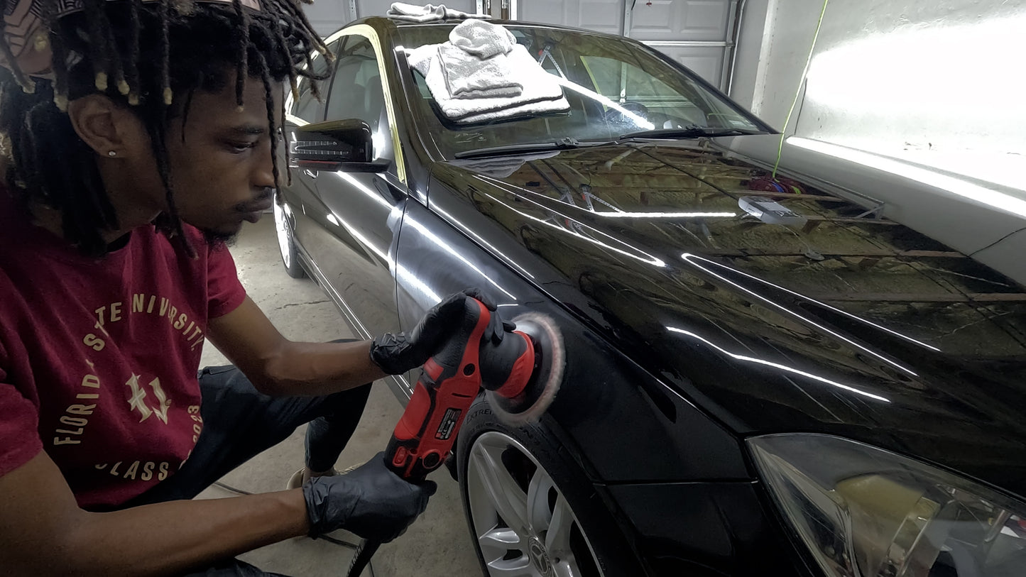 Technician performing paint correction on the fender of a limited edition Mercedes, removing swirl marks, scratches, and defects to restore a flawless, glossy finish.