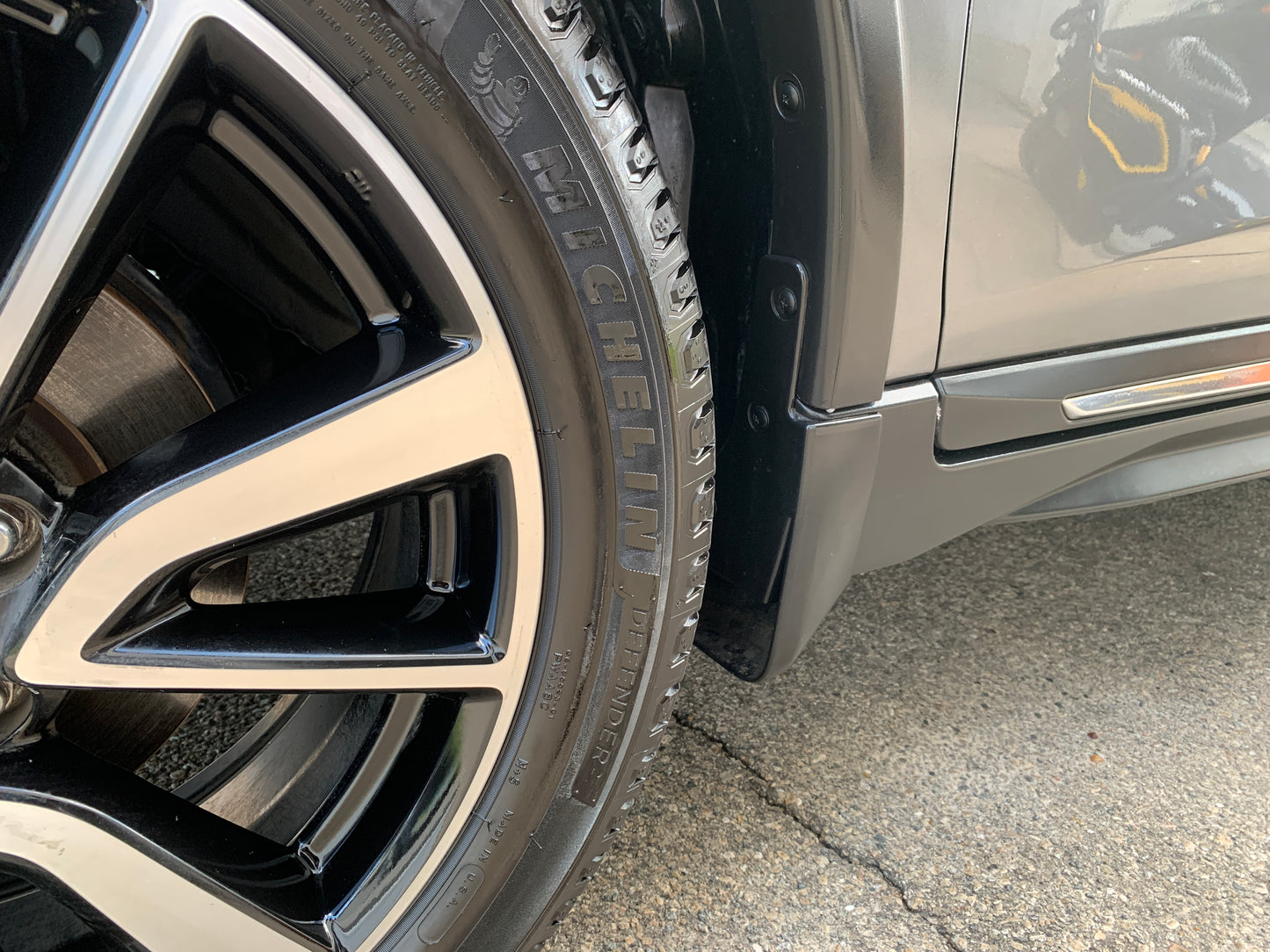 Close-up of a car's wheels looking shiny and protected after professional detailing, showcasing a spotless finish and tire conditioning