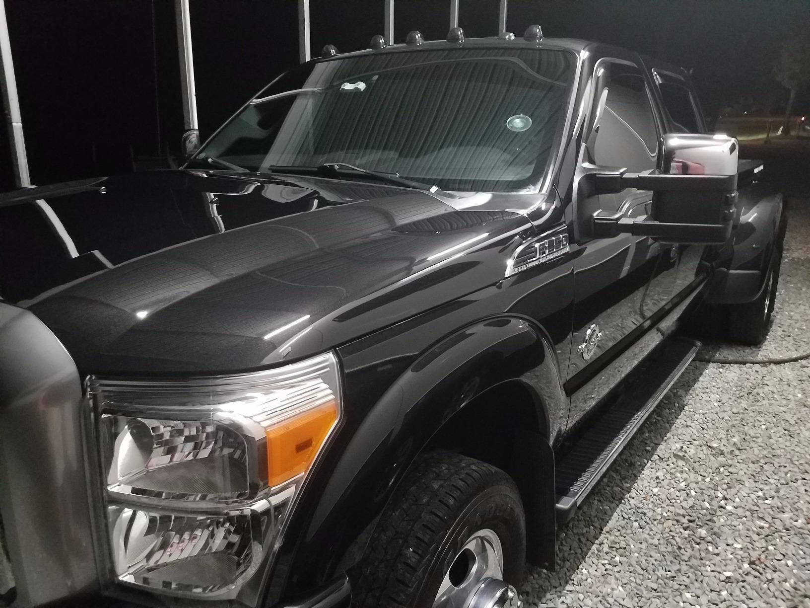 Black Ford Power Stroke after our two-step paint correction, ceramic coating, and headlight restoration, looking brand new.