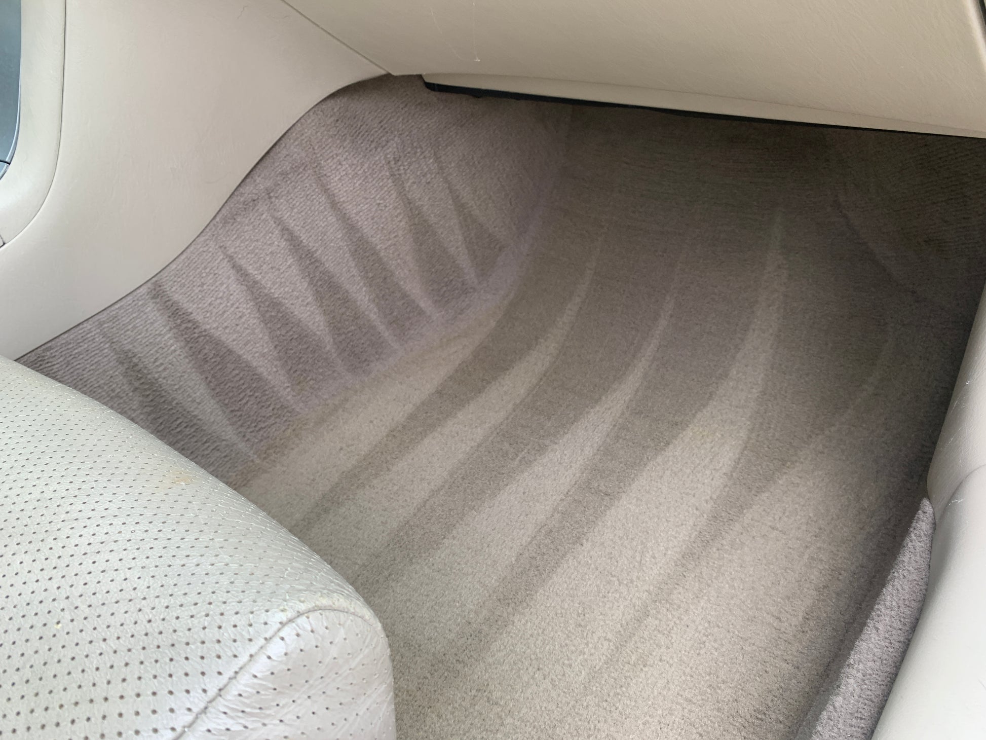 Triangle-shaped line art patterns on a vehicle’s carpet after professional interior detailing.