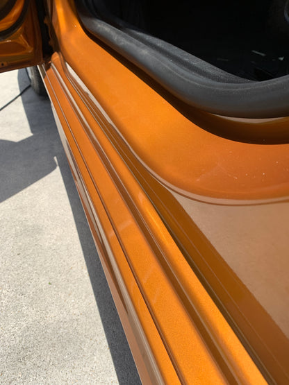 Clean door jambs of the orange Chevy after our paint enhancement service.