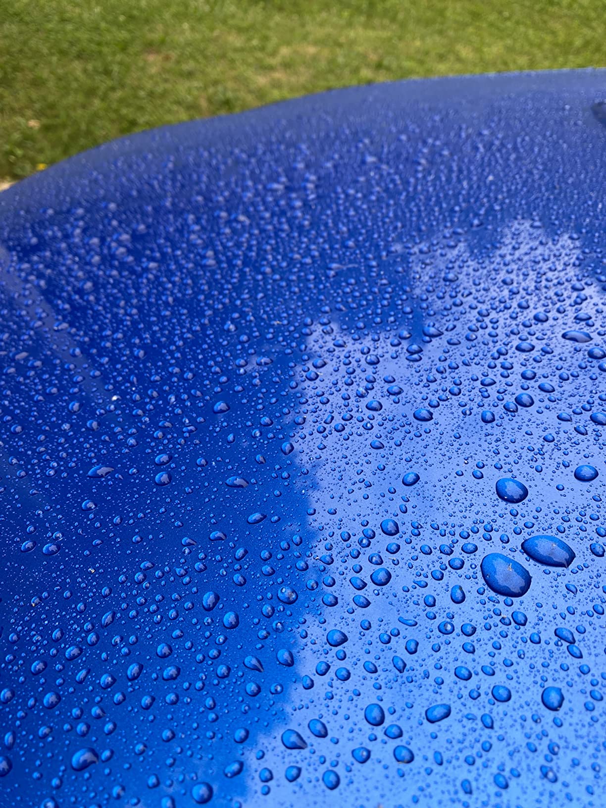 Close-up of graphene ceramic coating showcasing water beading on a vehicle surface.