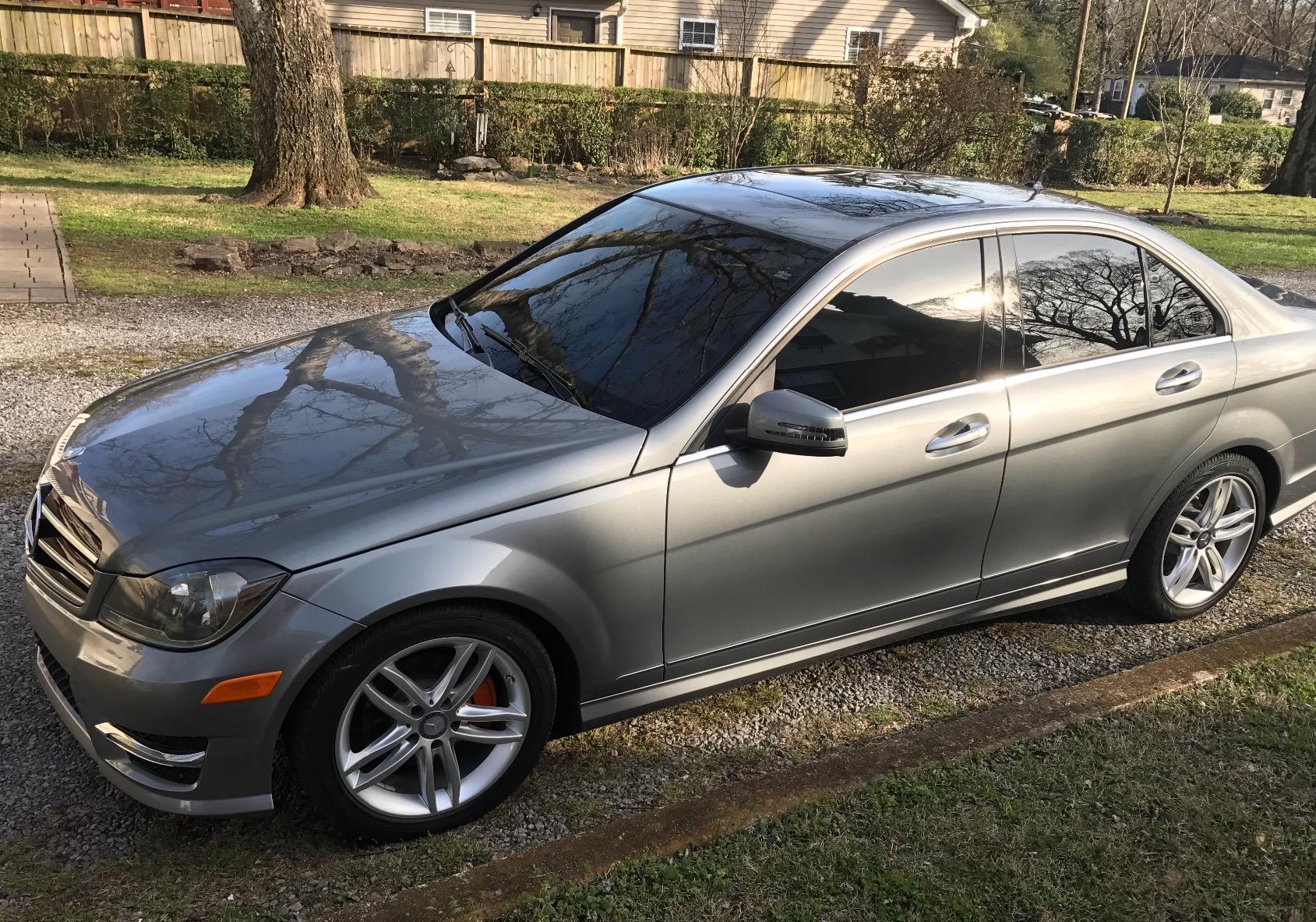Side view of the gray Mercedes after a paint enhancement service at Finishline Detailing Garage LLC. The FSU sticker is visible on the rear window, with the vehicle's paint reflecting a high-gloss finish after the two-stage paint correction.