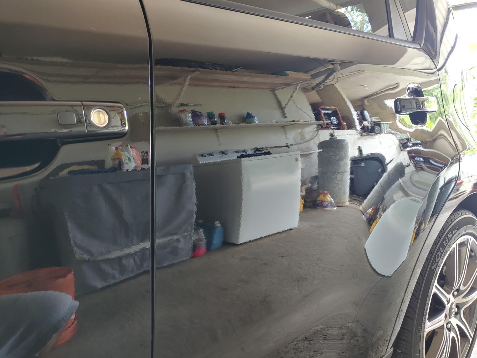Back door of a Kia Soul after a 2-stage paint correction, showcasing a high-gloss finish with reflections of the client's appliances in the door.