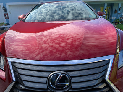 The glossy hood of a Lexus R350 reflecting the clouds, demonstrating the enhanced shine and protection from our ceramic coating package.