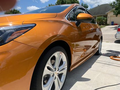 Orange Chevy after paint enhancement, low front shot showing the side of the vehicle after our wash and wax service.