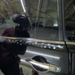 Close-up of a technician using a mini polisher to work on the detailed edges of a car door, removing defects and leaving a smooth, flawless finish.