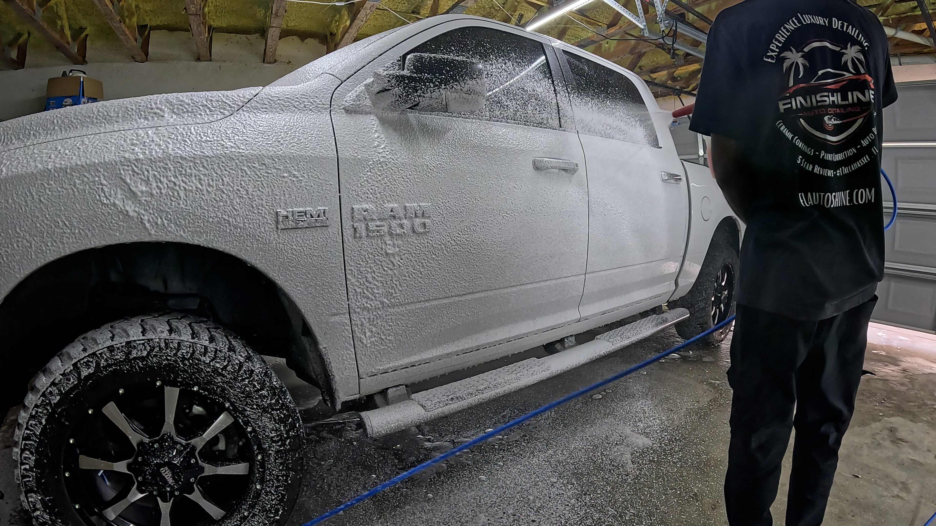 spraying pre-foam onto a RAM 1500, preparing the vehicle for a thorough wash and detailing.