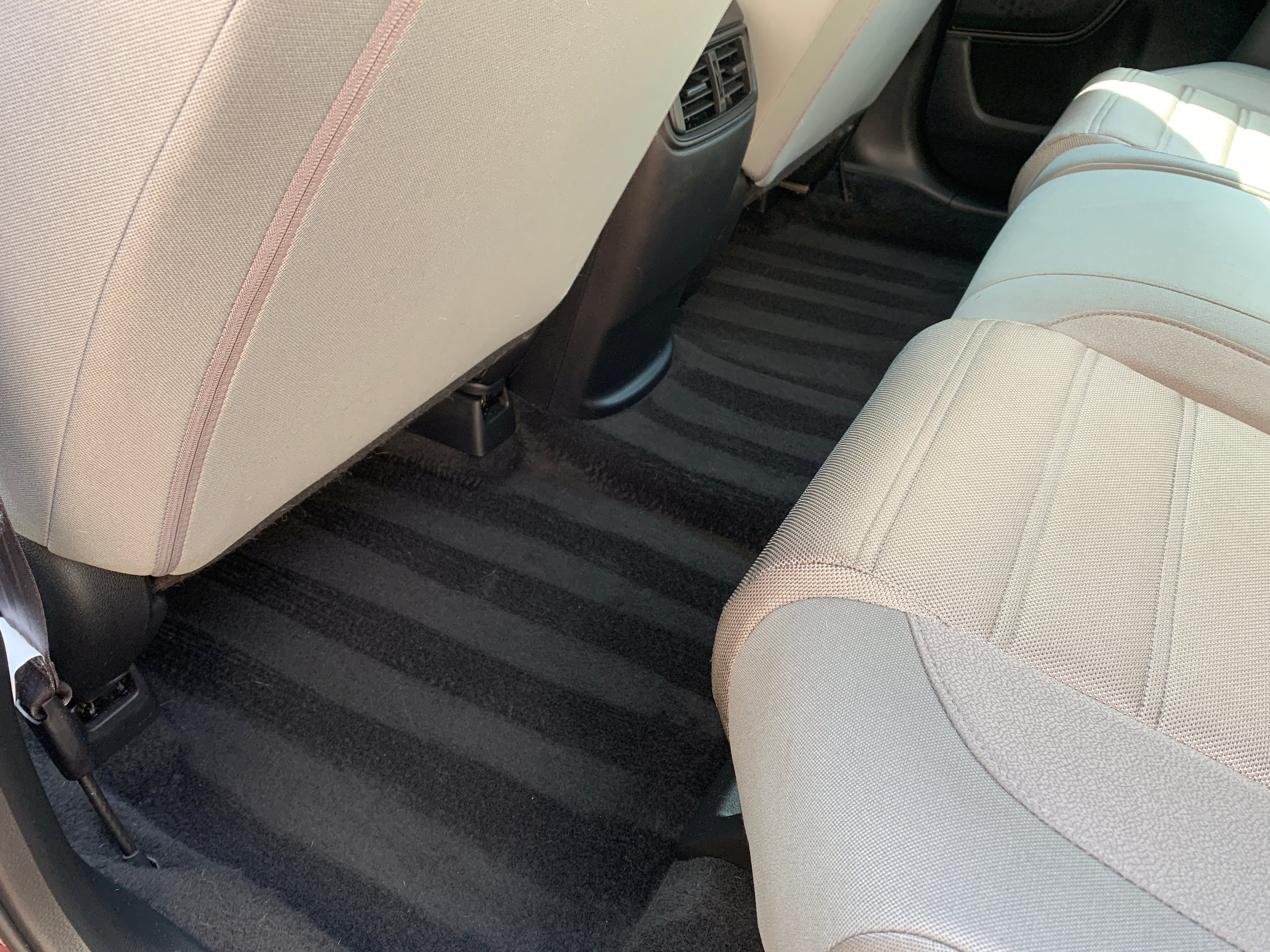Straight line art created in the second row of the vehicle’s carpet after a deep shampooing and professional detailing.