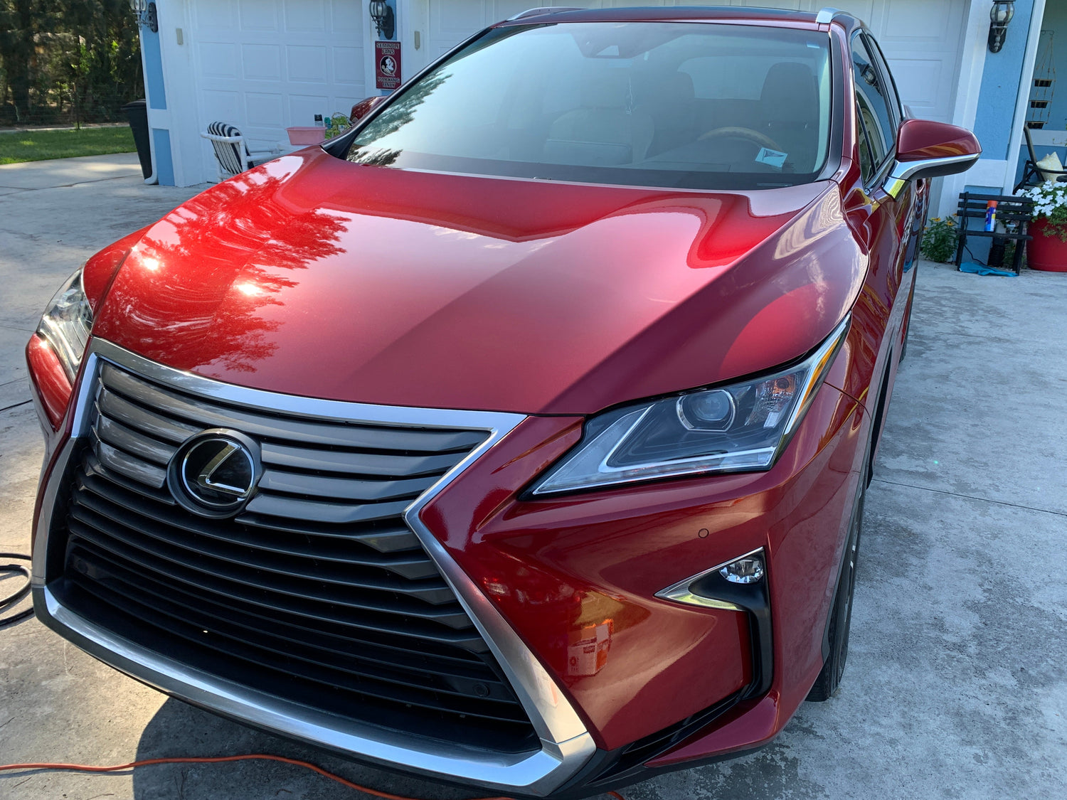 Wide-angle shot of a red car, showcasing the vibrant color and smooth, reflective finish after paint correction and ceramic coating