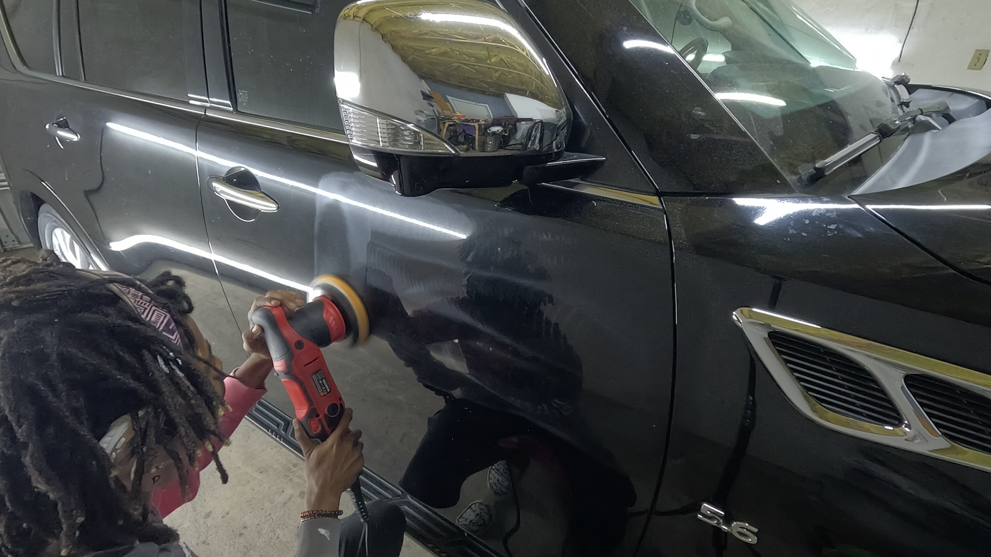 Technician performing paint correction on an SUV, removing multiple defects, swirl marks, and scratches to restore a smooth, glossy finish.