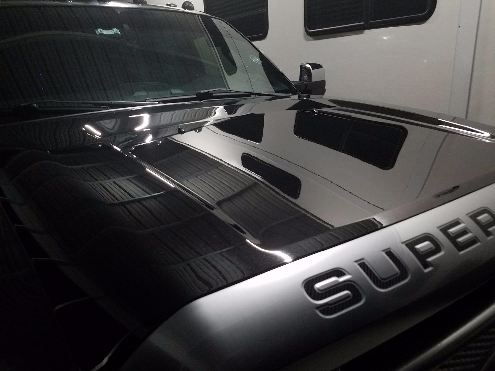 Close-up of a super shiny hood after a 2-stage paint correction, with the client's RV reflected in the paint.