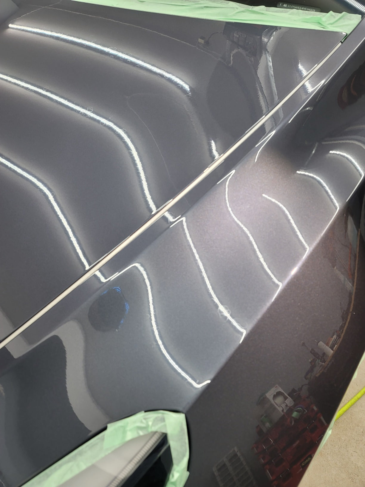 Tesla quarter panel after professional paint correction, showcasing a smooth, glossy finish with imperfections removed